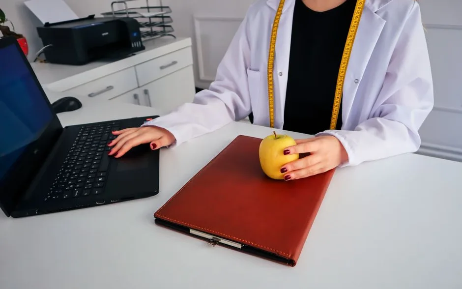 Bureau de travail avec ordinateur, notes et une pomme